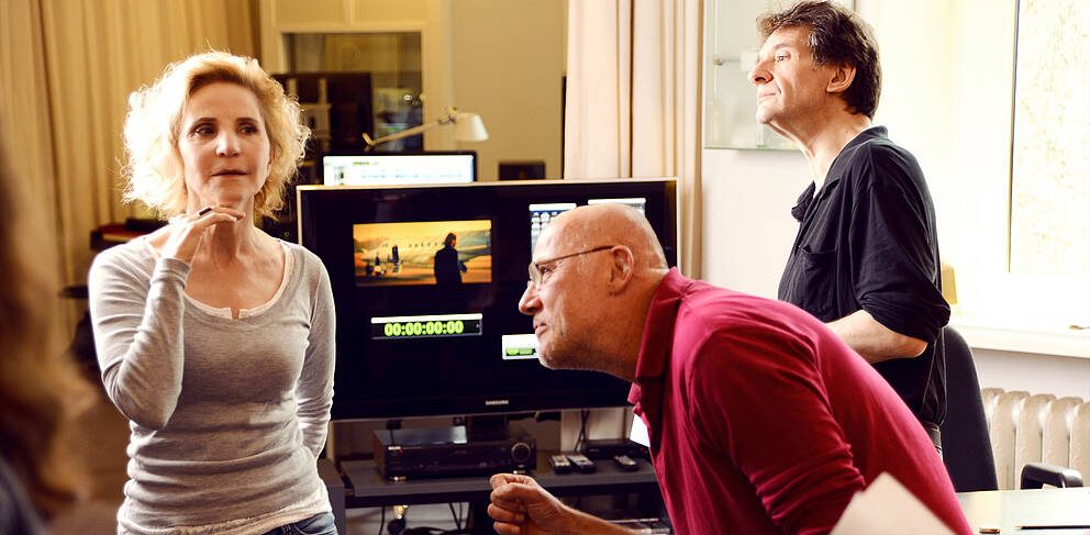 Katharina Koschny zeigt einem Kursteilnehmer die korrekte Haltung beim Mikrofonsprechen in der Akademie in Berlin.